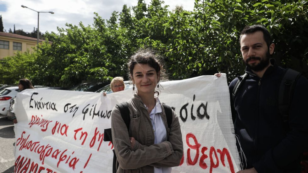Η δημοσιογράφος Σταυρούλα Πουλημένη μπροστά σε πανό υποστήριξης